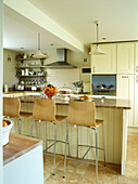Wood and chrome stools at breakfast bar in open plan Oxfordshire kitchen, England, UK