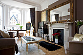 Sunlit living room with oversized gilt mirror on fireplace in Hove home East Sussex UK