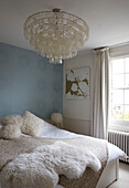 Honesty ceiling lamp in light blue bedroom of London home UK