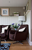 Brauner Sessel und Sofa im getäfelten Wohnzimmer eines Hauses in Cambridgeshire, Großbritannien