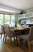 Dining table and wall mounted shelving unit in dining room of Cambridgeshire home UK