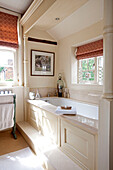 Recessed cream bath below window in Kent home, England, UK