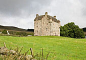 Stone castle exterior on hillside in Scotland UK