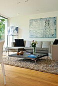 Low coffee table in seating are with artwork canvas in London home, England, UK