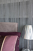 Muted metallic bedside lamp and beaded curtain in London home, England, UK