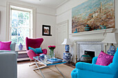 Colourful furniture in living room with large window and fireplace