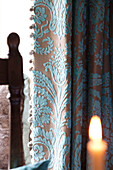 Fabric detail and lit candle in Cotswolds home UK
