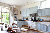 Light blue fitted units in kitchen with chocolate on table, East Sussex home, England, UK
