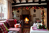 Fairylights garland above lit fire in timber framed Sussex home UK
