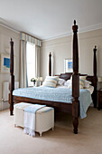 Four postered dark wood bed in London home UK