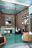 Home extension with brick wall and glass ceiling and floors in contemporary London townhouse, UK