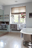Freestanding metallic silver bath and mirrored cabinets in contemporary London townhouse, UK