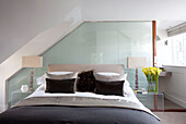 Double bed with matching lamps and brown cushions in contemporary London townhouse, UK