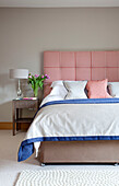 Rot und weiß kariertes gepolstertes Kopfteil in einem Schlafzimmer in den Cotswolds UK