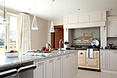 Klare Pendelleuchten über der Küchenarbeitsplatte in einem Haus in Suffolk UK