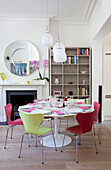 Pinkfarbene und gelbe Stühle am Esstisch in einem modernen Londoner Haus, UK