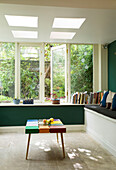 Conservatory extension with books on sill below open window in London home, England, UK