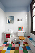 Mehrfarbiger Boden im weiß gefliesten Badezimmer eines Londoner Hauses, England, UK