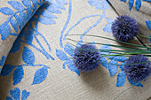 Schnittblumen und blauer, floral gemusterter Stoff in einem Haus in London, England, UK