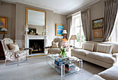 Matching armchairs at fireplace in drawing room of contemporary London townhouse, England, UK