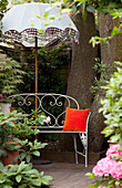 Parasol with metal bench in back garden of London home, UK