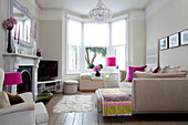 Weißes und rosafarbenes Wohnzimmer in einem modernen Londoner Haus, UK
