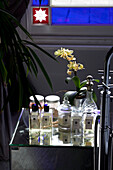 Glas-Toilettenartikel und Orchidee im Badezimmer eines modernen Hauses in London, UK