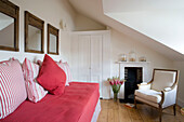 Pink daybed with wood-framed mirrors in attic conversion