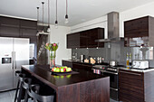 Dark wood contemporary kitchen with stainless steel fittings, Hove, East Sussex, England, UK