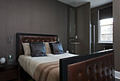 Buttoned leather bed in London townhouse bedroom