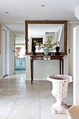 Large mirror and antique urn in hallway of Kent home, England, UK