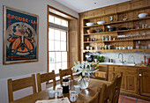 Regal aus hellem Holz in Londoner Küche mit französischem Theaterplakat