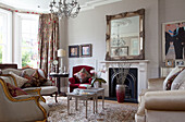Silver framed mirror on mantlepiece with vintage furniture in London home, UK