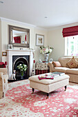 Three-piece suite with ottoman and red furnishings in living room of Kent cottage, England, UK
