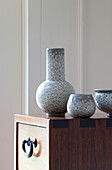 Graue Vase und Schleife auf hölzernem Beistelltisch in einem Einfamilienhaus in Herefordshire, England, UK