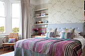Double bed with recessed shelving in contemporary London townhouse, England, UK