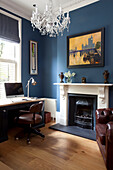 Brown leather chair at desk with computer in blue study of classic London townhouse, UK