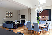 Table for eight in open plan dining and living room of classic London townhouse, UK