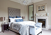 Light blue furnishings with buttoned headboard in classic London bedroom, UK