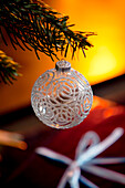 White Christmas glitter bauble hangs from Christmas tree in London home, UK