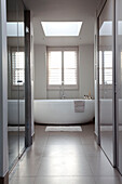 Weiße freistehende Badewanne im gefliesten Badezimmer eines modernen Hauses in London, Vereinigtes Königreich
