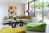 Lime green seating with arc lamp and canvas in contemporary London home, England, UK