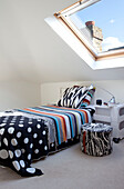 Funky bed cover in attic bedroom conversion, contemporary London home, UK