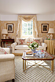 Teaset on glass topped coffee table in sunlit living room of Sussex farmhouse, England, UK