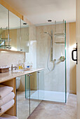 Mirrored bathroom cabinets and glass shower cubicle in Sussex farmhouse, England, UK