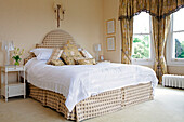 Co-ordinating headboard and valence on double bed in Sussex country house, England, UK