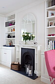 Fireplace detail with alcove shelving in London townhouse, England, UK