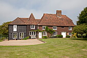 Lawned exterior and driveway to Maidstone farmhouse in Kent, England, UK