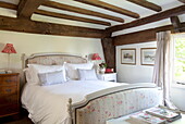 Upholstered bed in low beamed rom of Maidstone farmhouse, Kent, England, UK