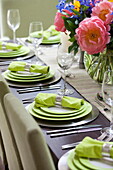 Lime green plates and napkins on dining table in contemporary London townhouse, England, UK